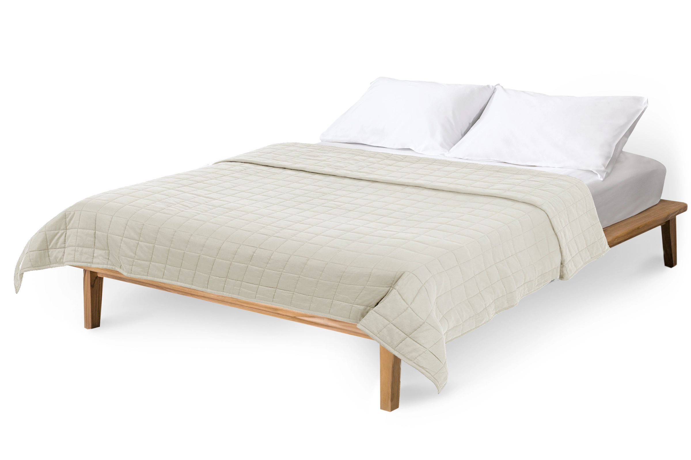 Bed with beige quilt and white pillows on a white background