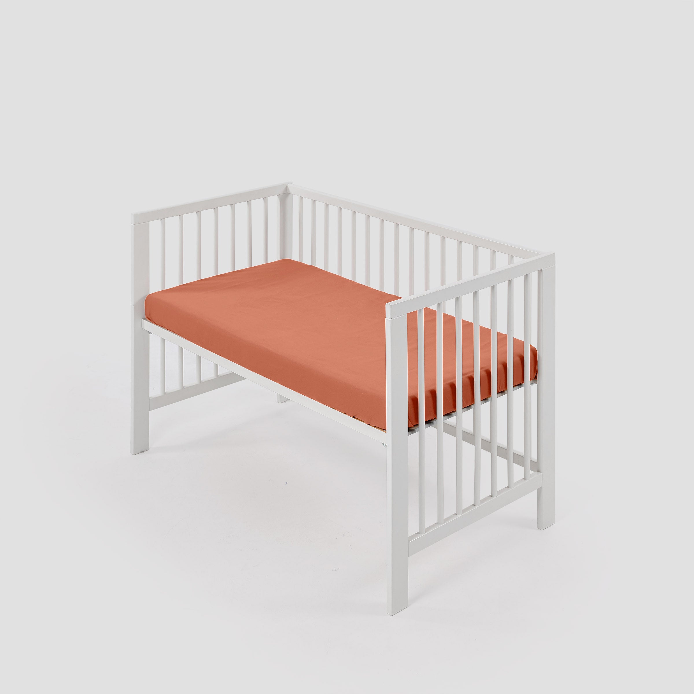 organic-classic-baby-cot-fitted-sheet-in-Peach-colour-inside-a-cot-by-sojao