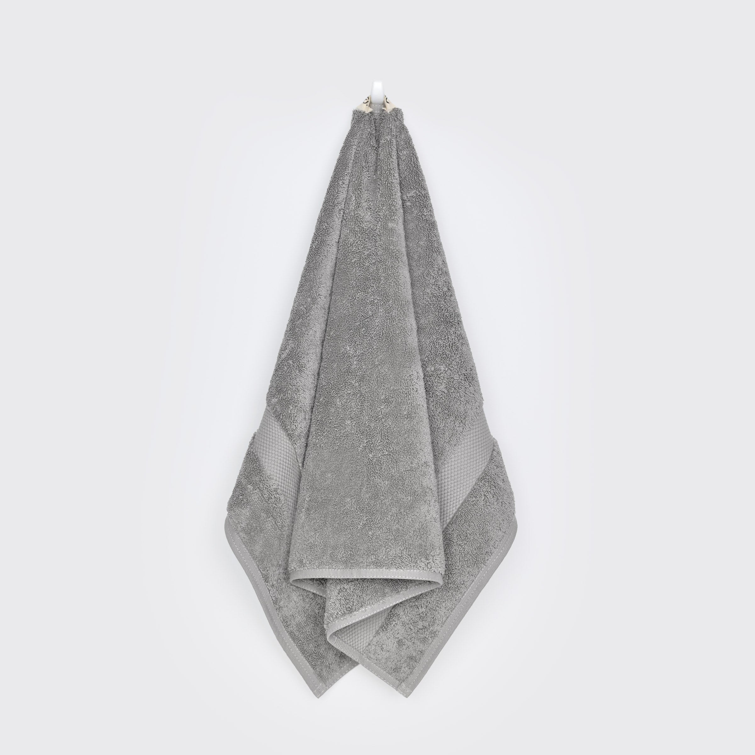 organic-cotton-hand-towel-in-stone-colour-hanging-on-a-wall-by-sojao