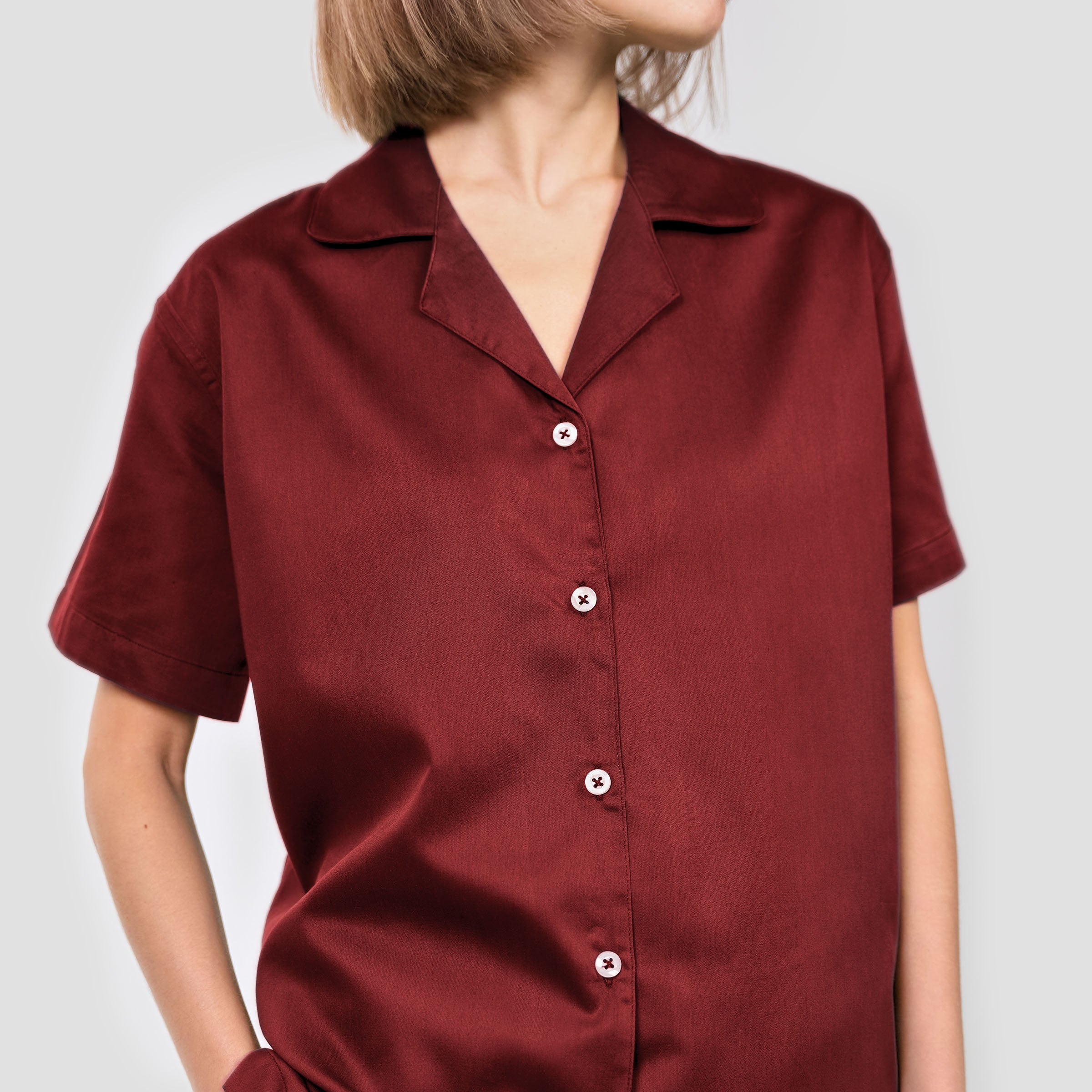 Maroon shirt worn by a person on a plain background