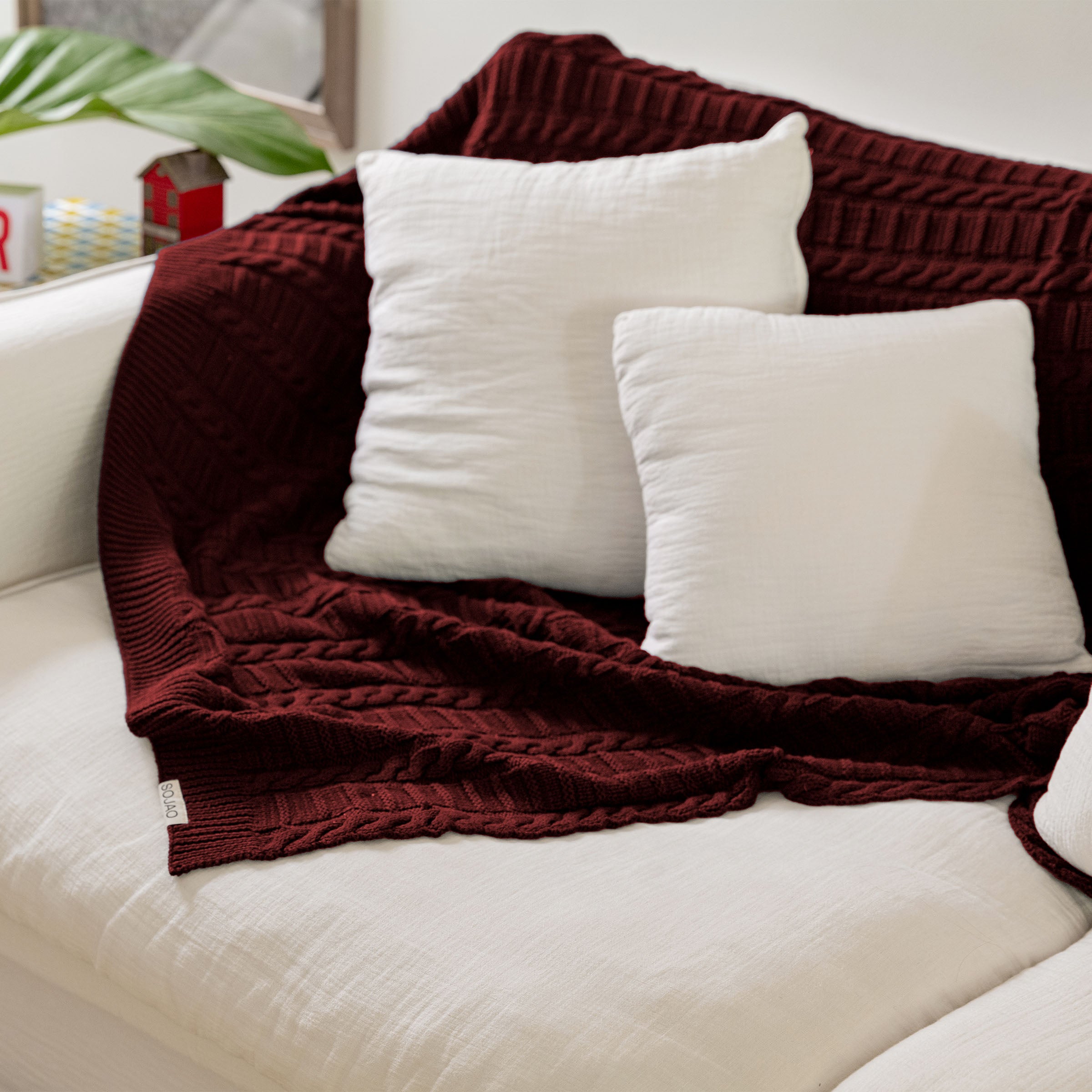 organic-cotton-cable-knit-throw-in-maroon-colour-on-the-sofa-by-sojao