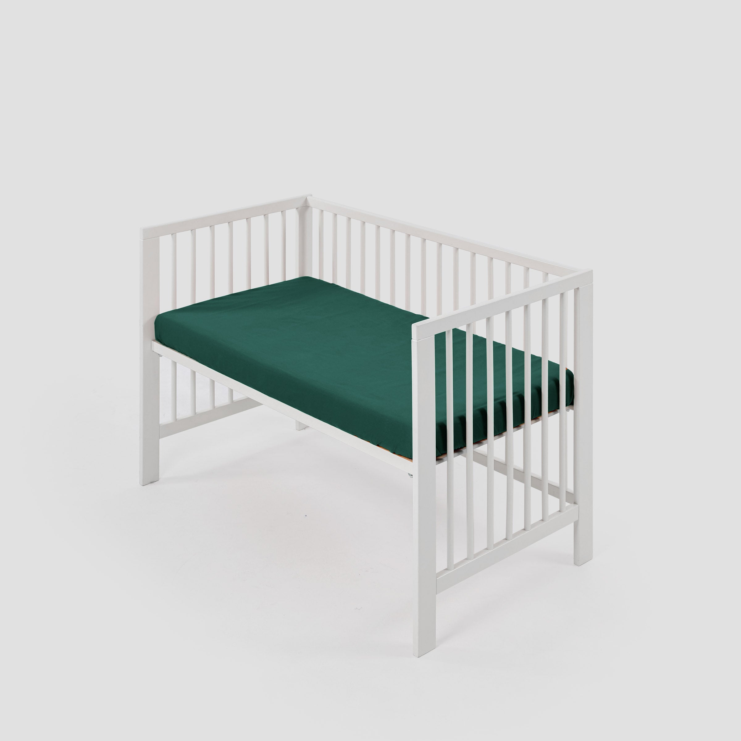 organic-classic-baby-cot-fitted-sheet-in-forest-colour-inside-a-cot-by-sojao