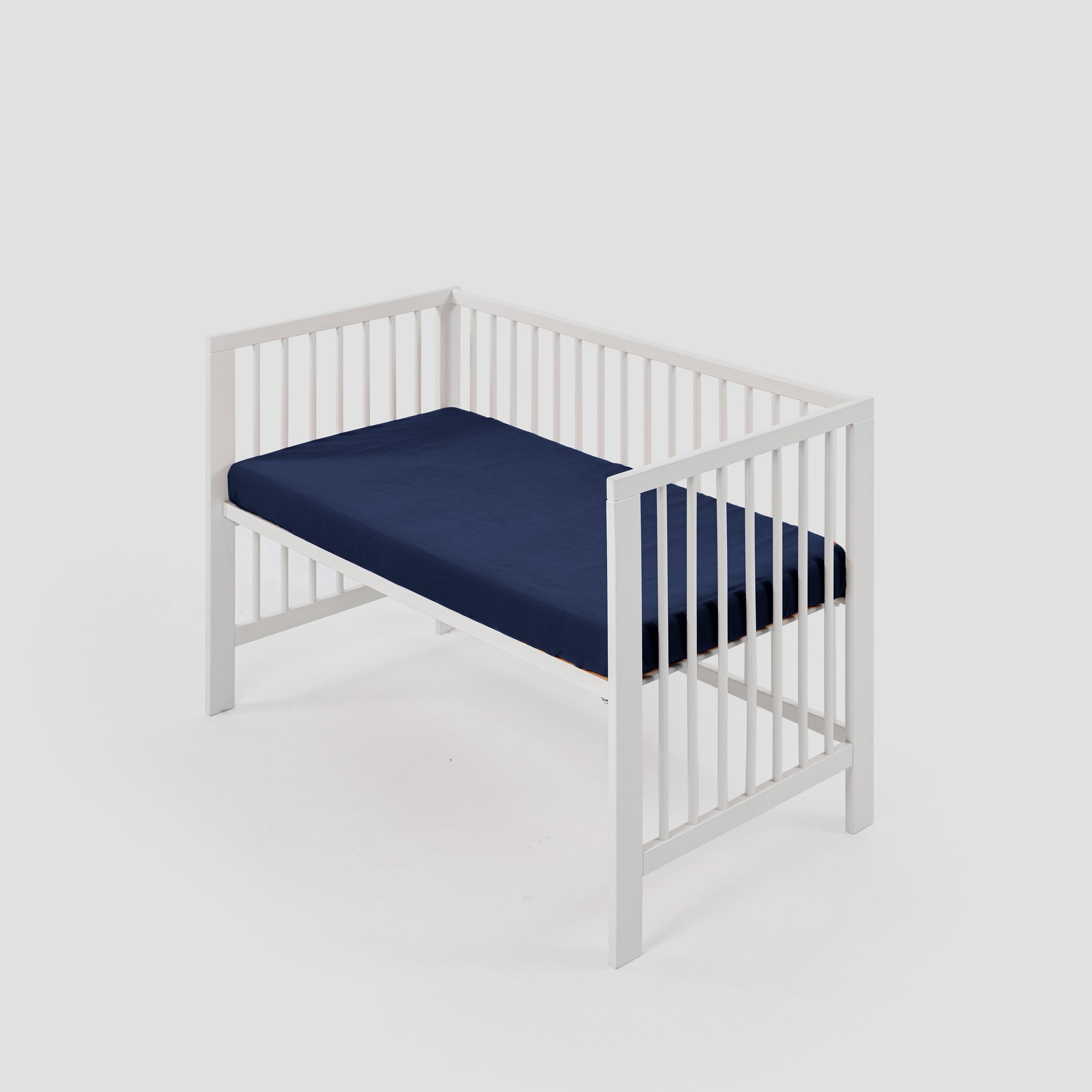 organic-classic-baby-cot-fitted-sheet-in-navy-colour-inside-a-cot-by-sojao