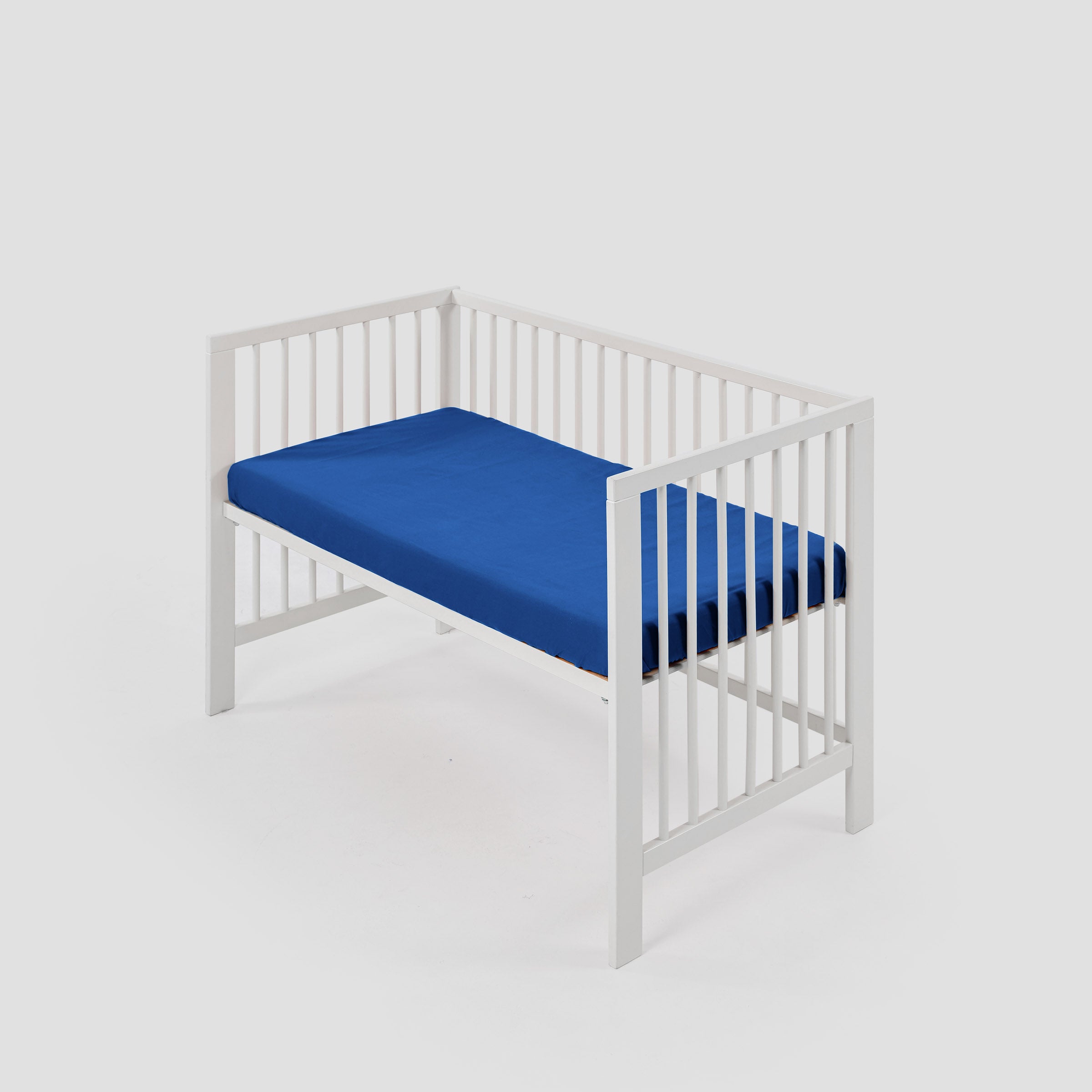 organic-crisp-baby-cot-fitted-sheet-in-cobalt-colour-inside-a-cot-by-sojao