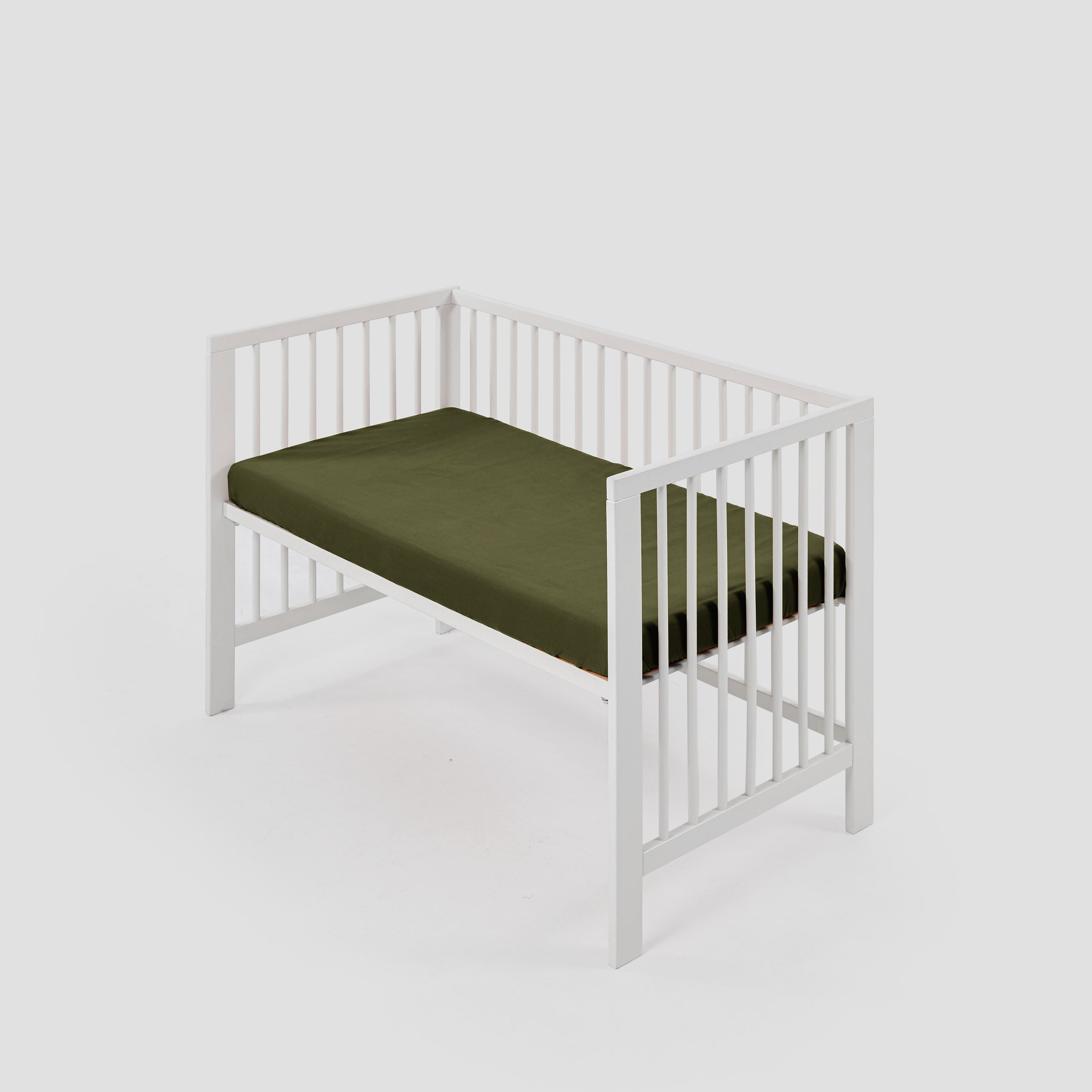 organic-crisp-baby-cot-fitted-sheet-in-olive-colour-inside-a-cot-by-sojao