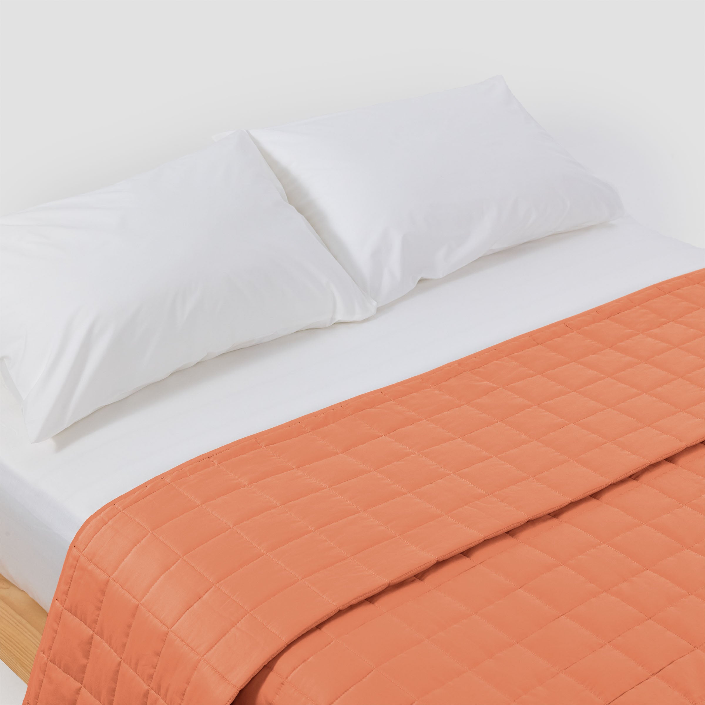 organic-cotton-quilt-in-peach-colour-on-a-bed-by-sojao